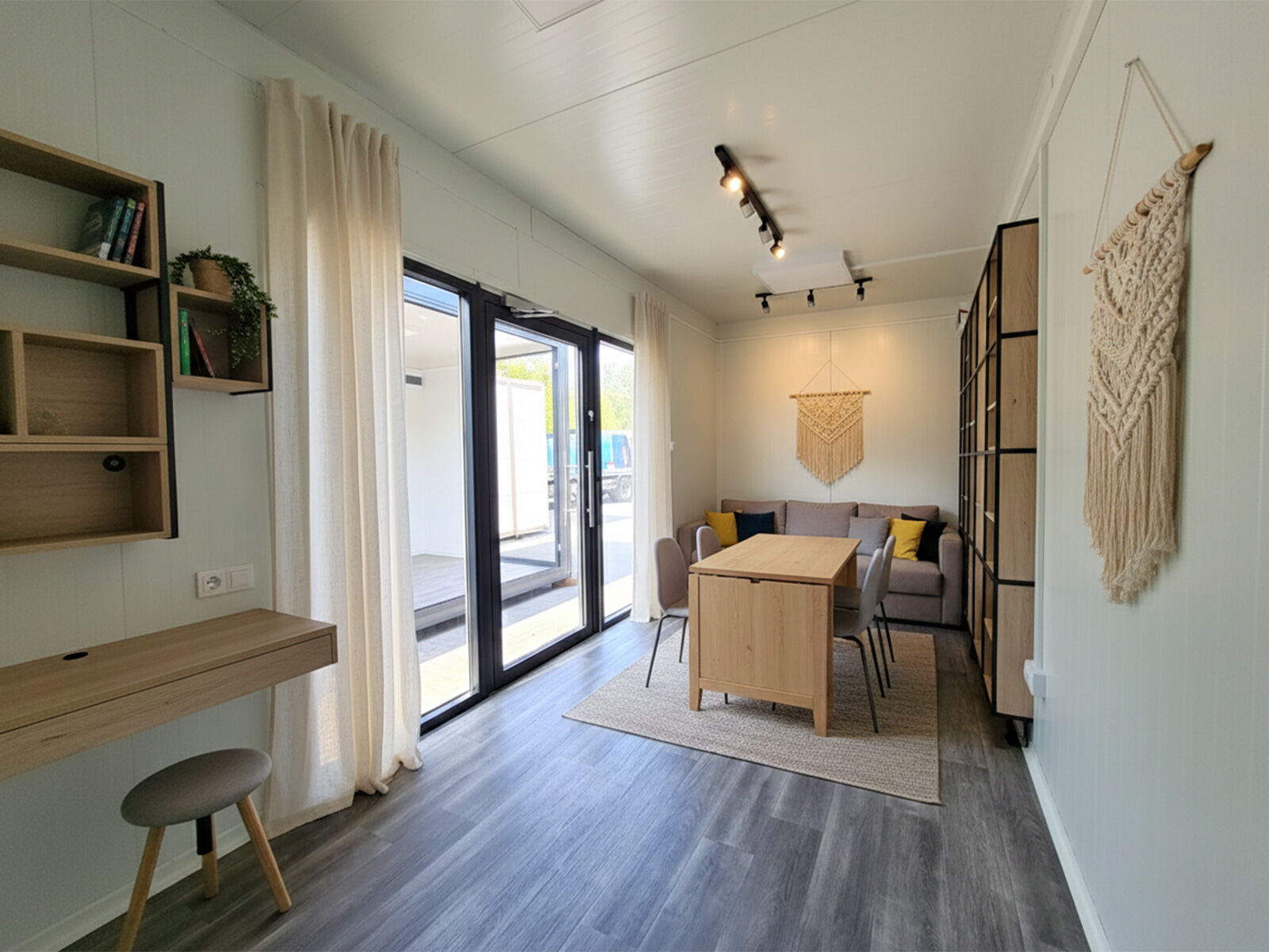 Wohncontainer mit Essbereich, Sofa und großer Terrassentür