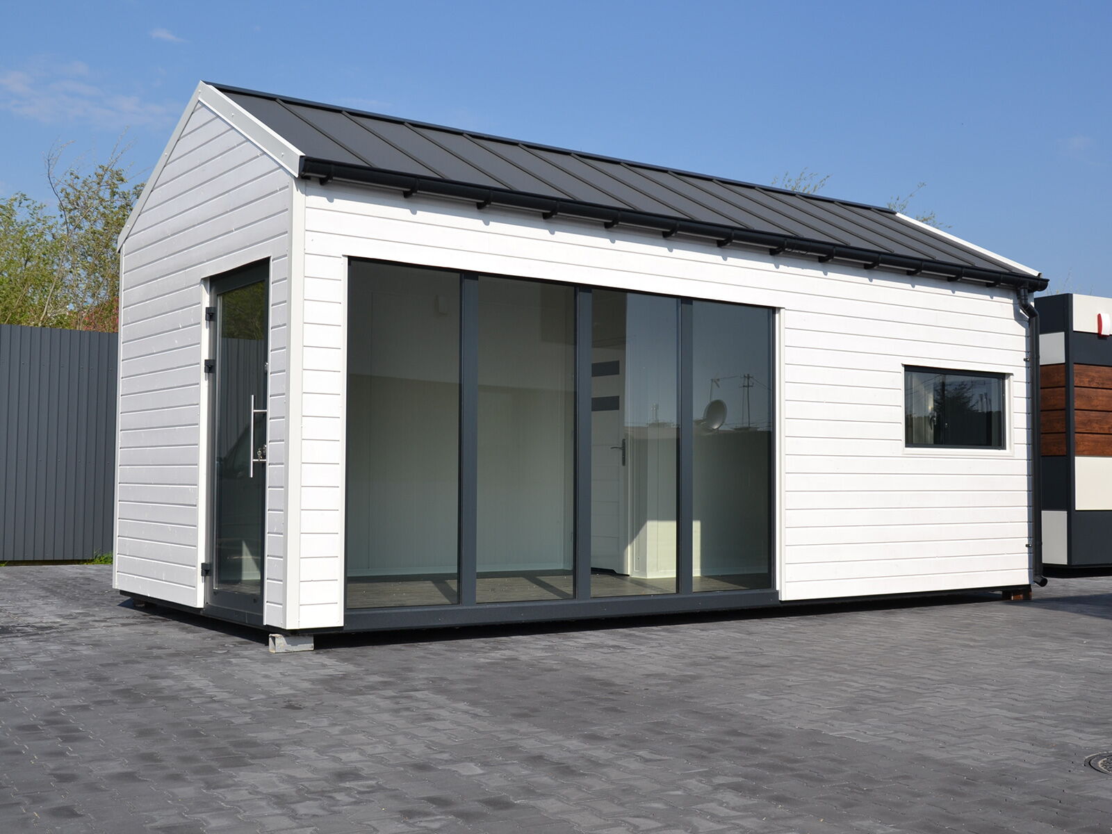 Wohncontainer mit Satteldach und großer Glasfront