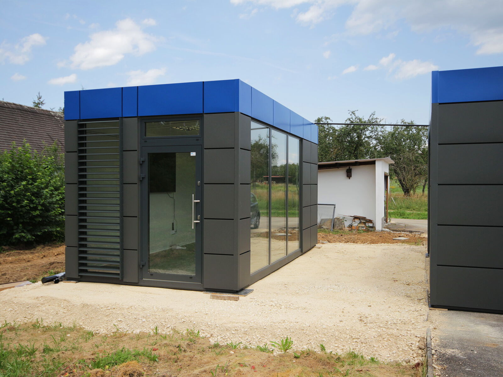 Modernes Verkaufsmodul mit Glasfassade und Kassettenoptik im Außenbereich