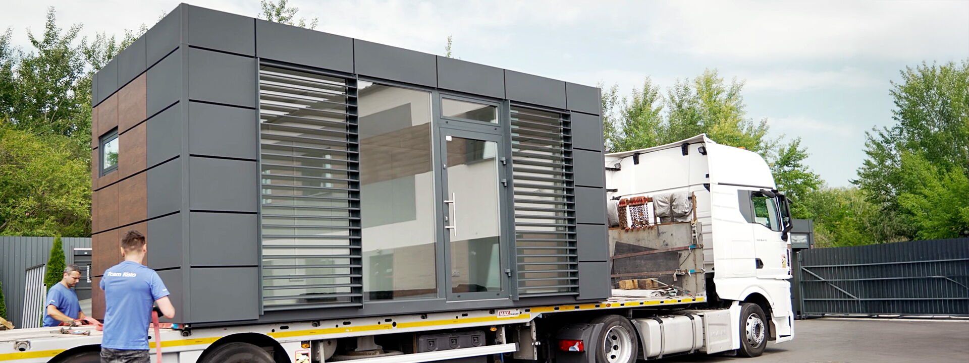 Modulcontainer mit Glasfront wird per Lkw geliefert