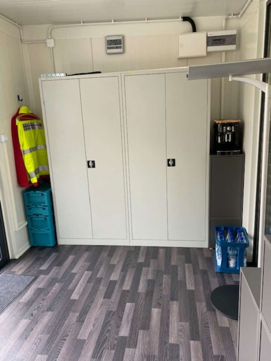 Innenbereich eines Bürocontainers mit Schränken und Lagerbereich für Arbeitskleidung