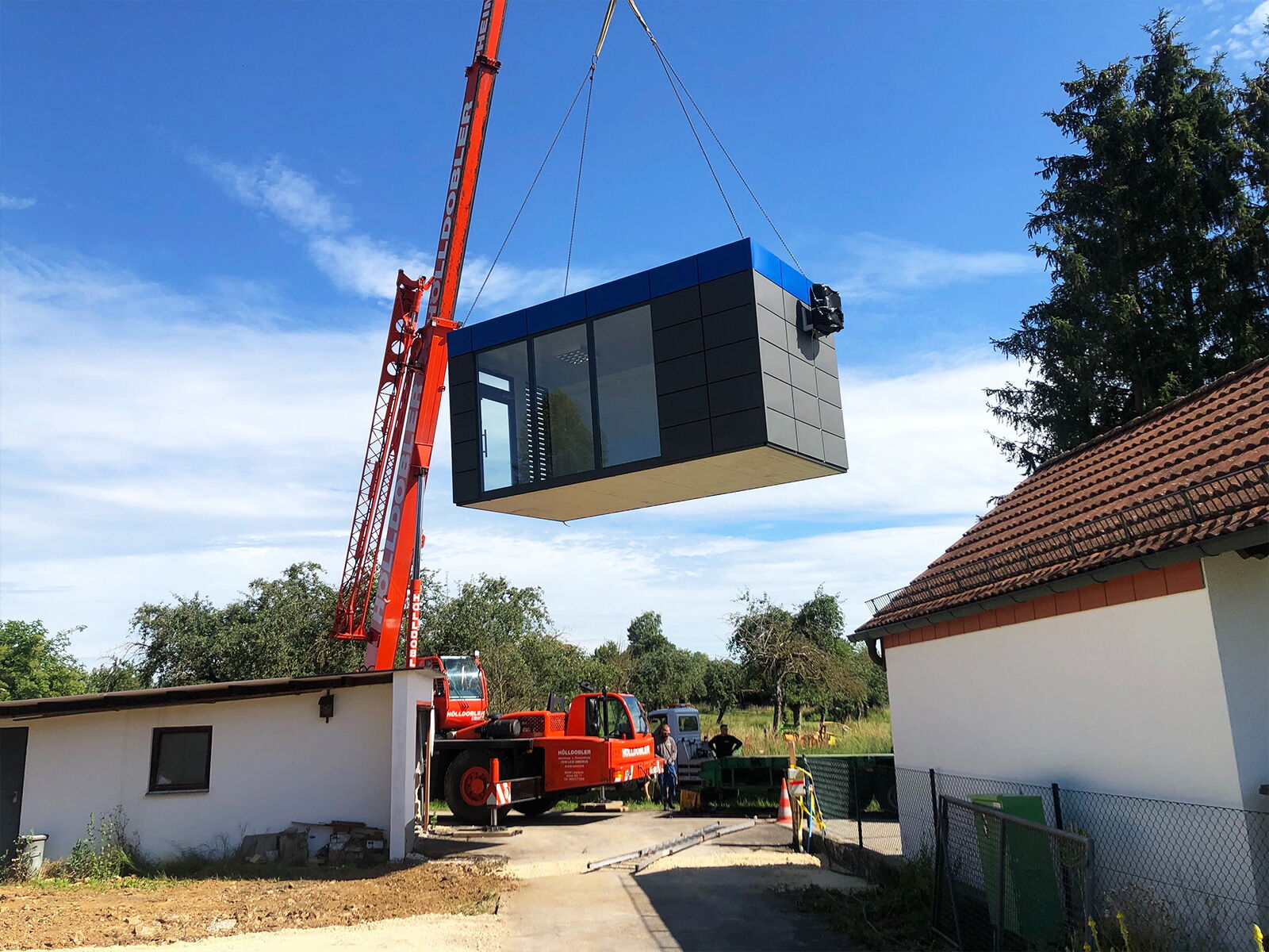 Anlieferung und Installation eines Containers per Autokran im Wohngebiet