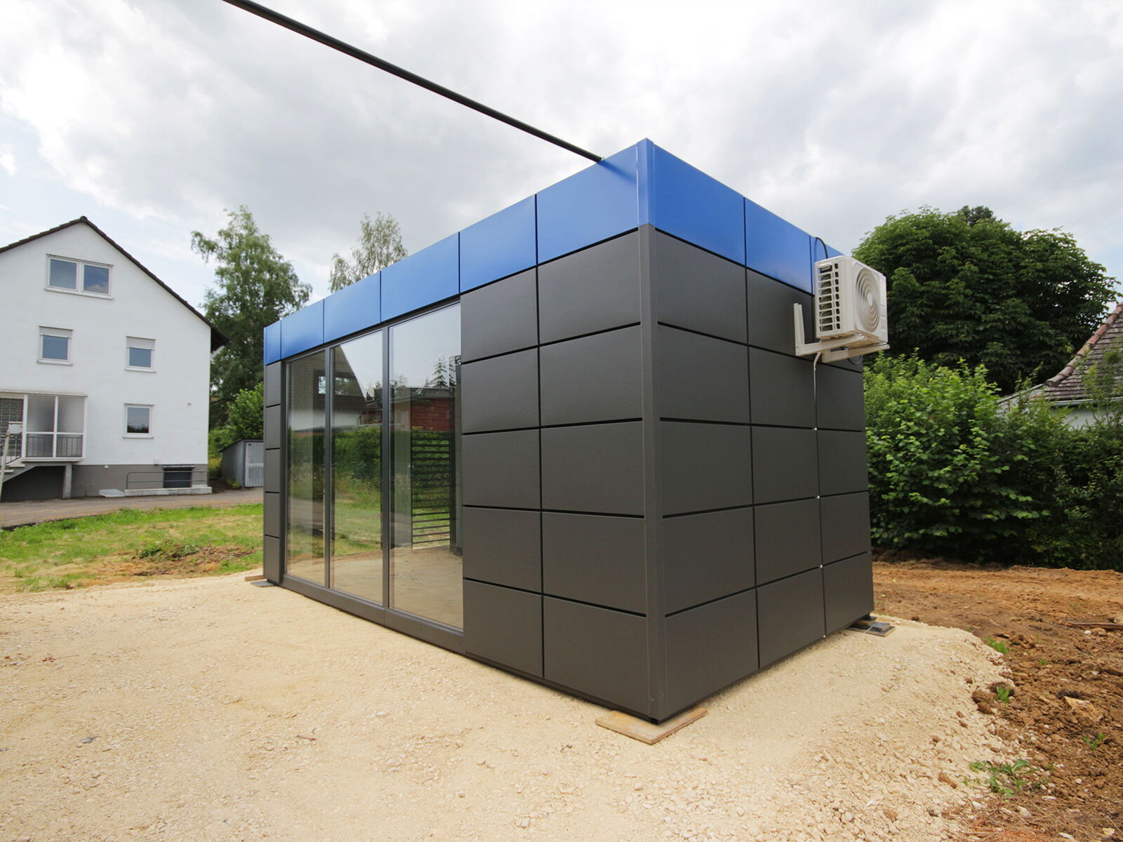 Kompakter Bürocontainer mit Glasfront und Klimaanlage im Außenbereich