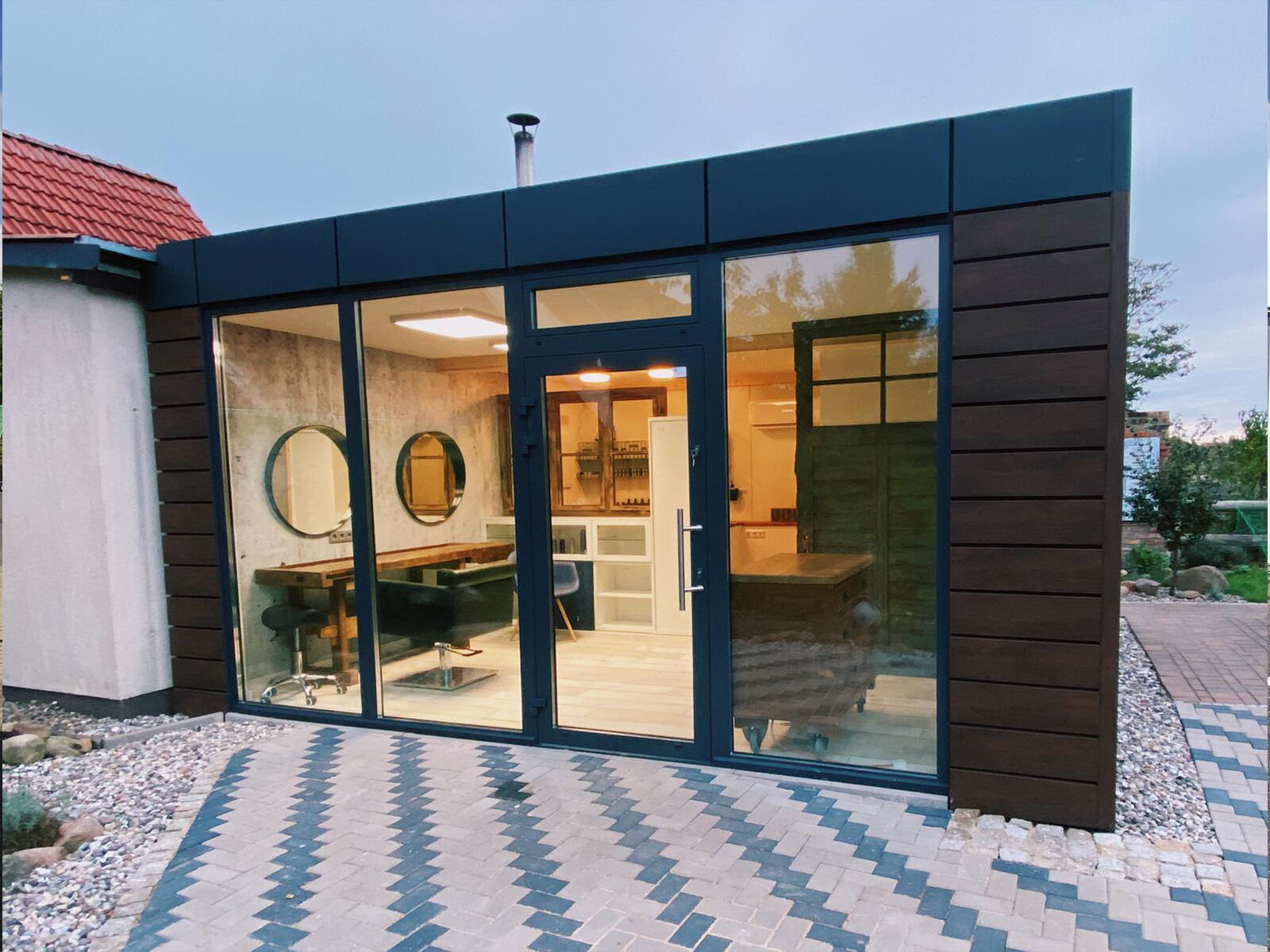 Modernes Verkaufsmodul mit Glasfront und stilvoller Innenausstattung im Gartenbereich