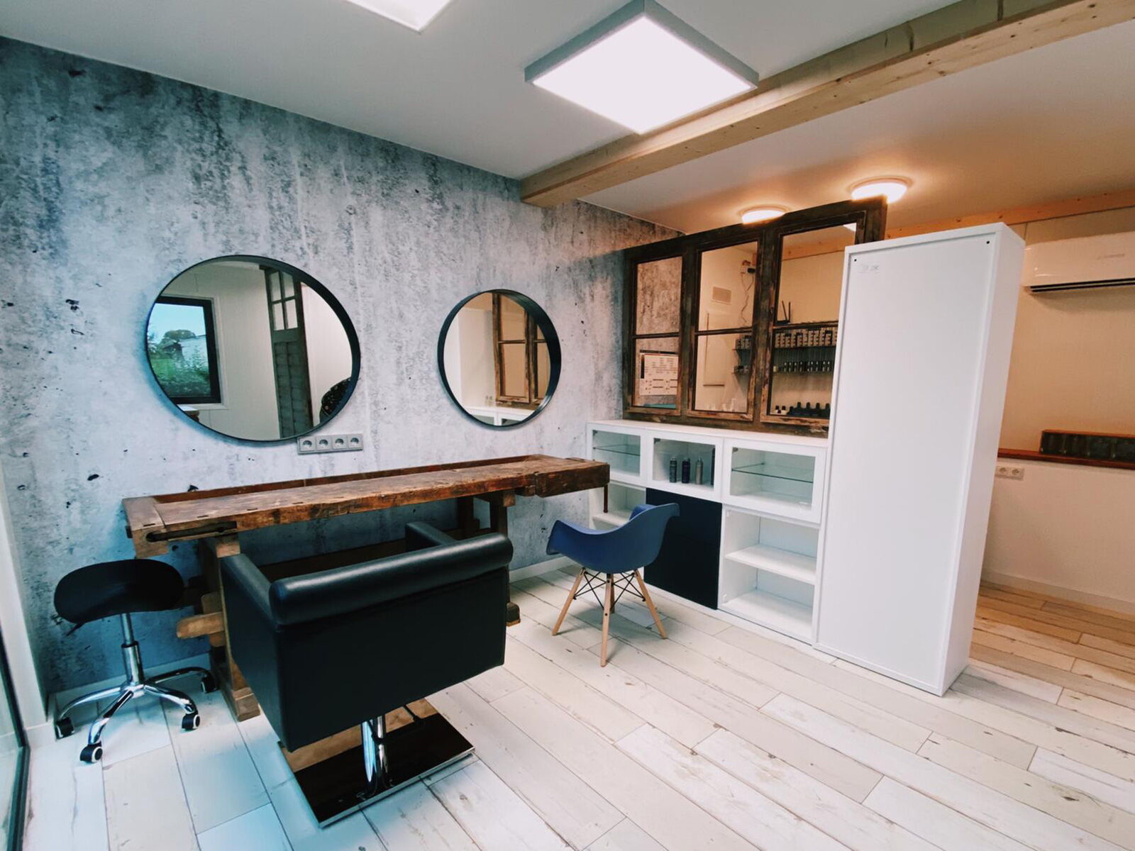 Ausgebauter Container als Friseurstudio mit Spiegeln, Holzarbeitsplatz und Stühlen