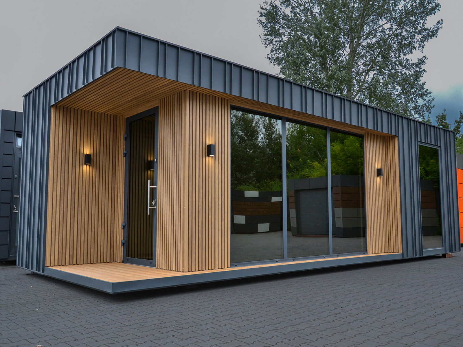 Moderner Wohncontainer mit Holzlamellen, Metallfassade und großer Glasfront