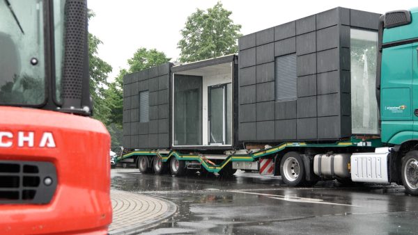 Vorgefertigter Container mit Verkleidung wird per LKW angeliefert