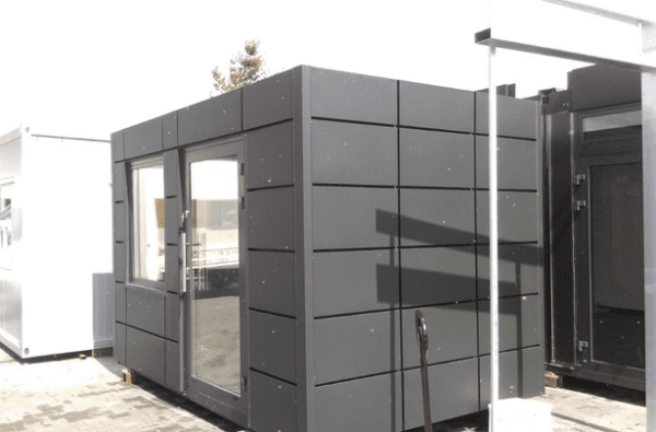 Modulcontainer in Schwarz bei Tageslicht auf dem Werksgelände