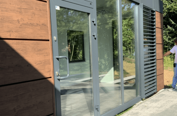 Eingangsbereich eines Bürocontainers mit Holzverkleidung und Lamellen